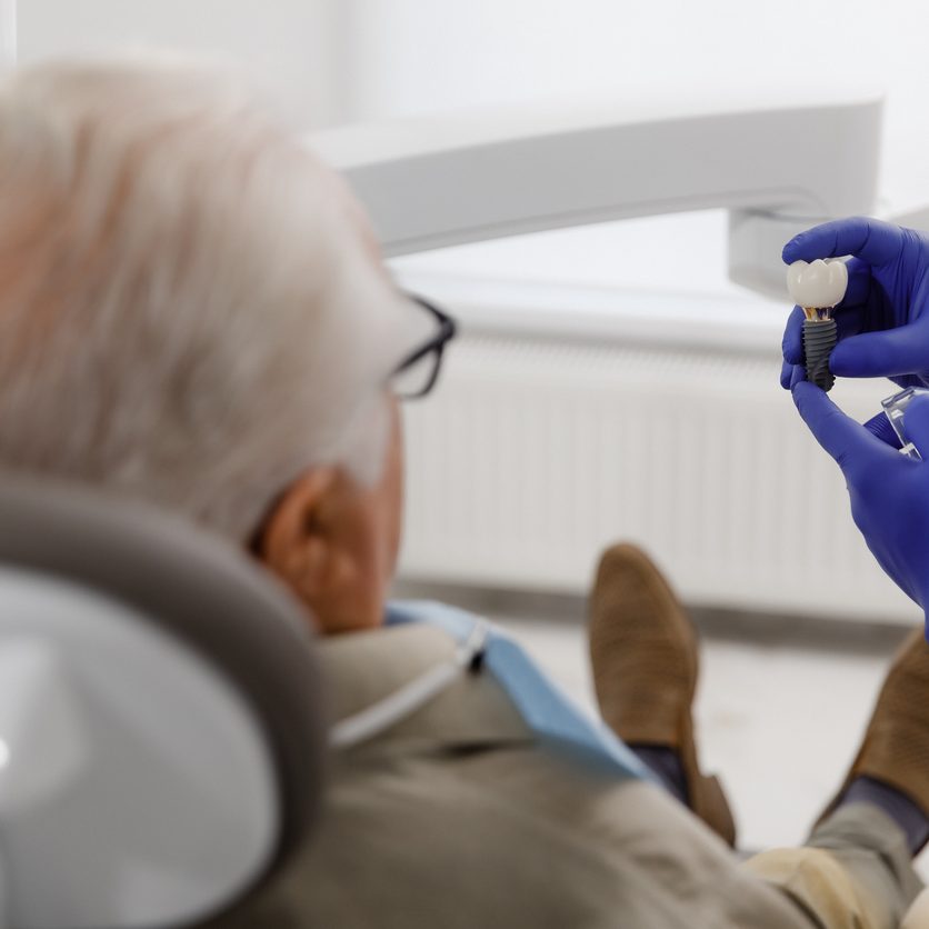 Oral care treatment for a old man patient came for a visit to the dentist he laying down on the dentist chair and have a checkup the doctor using medical instruments for treatment. Dentist